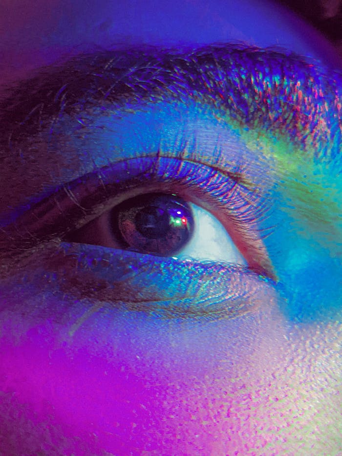 Colorful close-up of a woman's eye with artistic rainbow light effects. Ideal for creative projects.